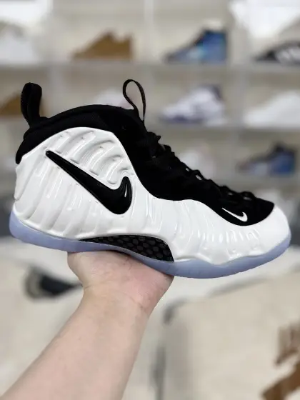 ▪️S版外贸 Nike Foamposite Pro 舒适百搭 中帮 复古篮球鞋 男款 白黑色 喷泡 ▪️ (40 40.5 41 42 42.5 43 44 44.5 45 46 47) ▪️货号:HF0794-200 ▪️Nike Foamposite Pro是一款经典的篮球鞋.起源于1997年,设计师Eric Avar从甲虫的外壳获得灵感,创造了Foamposite材料,并首次运用在了喷泡鞋上.Foamposite Pro在外观上更有创新,加入了硕大的Nike Swoosh,使其更加现代化和时尚化.这款鞋最初是为皮蓬设计的,但后来成为便士哈达威的签名鞋,具有极高的历史价值和纪念意义.Foamposite Pro采用了独特的Foamposite材料,这种材料坚固耐用,给人一种甲壳虫外壳的质感,为鞋子提供了出色的支撑性和保护性.Foamposite Pro搭载了Zoom Air气垫技术,为双脚提供超轻、超舒适的缓震保护,让穿着者在运动过程中能够享受到更佳的缓震体验.鞋子底部采用人字型外底花纹设计,抓地性能一流,耐磨度极佳,能够在各种场地条件下保持稳定的抓地力,为穿着者提供强大的后盾.Foamposite Pro适用于各种篮球比赛和日常穿着场景.其时尚前卫的外观和卓越的性能表现使得它成为了广大篮球爱好者和潮流消费者的首选之一.